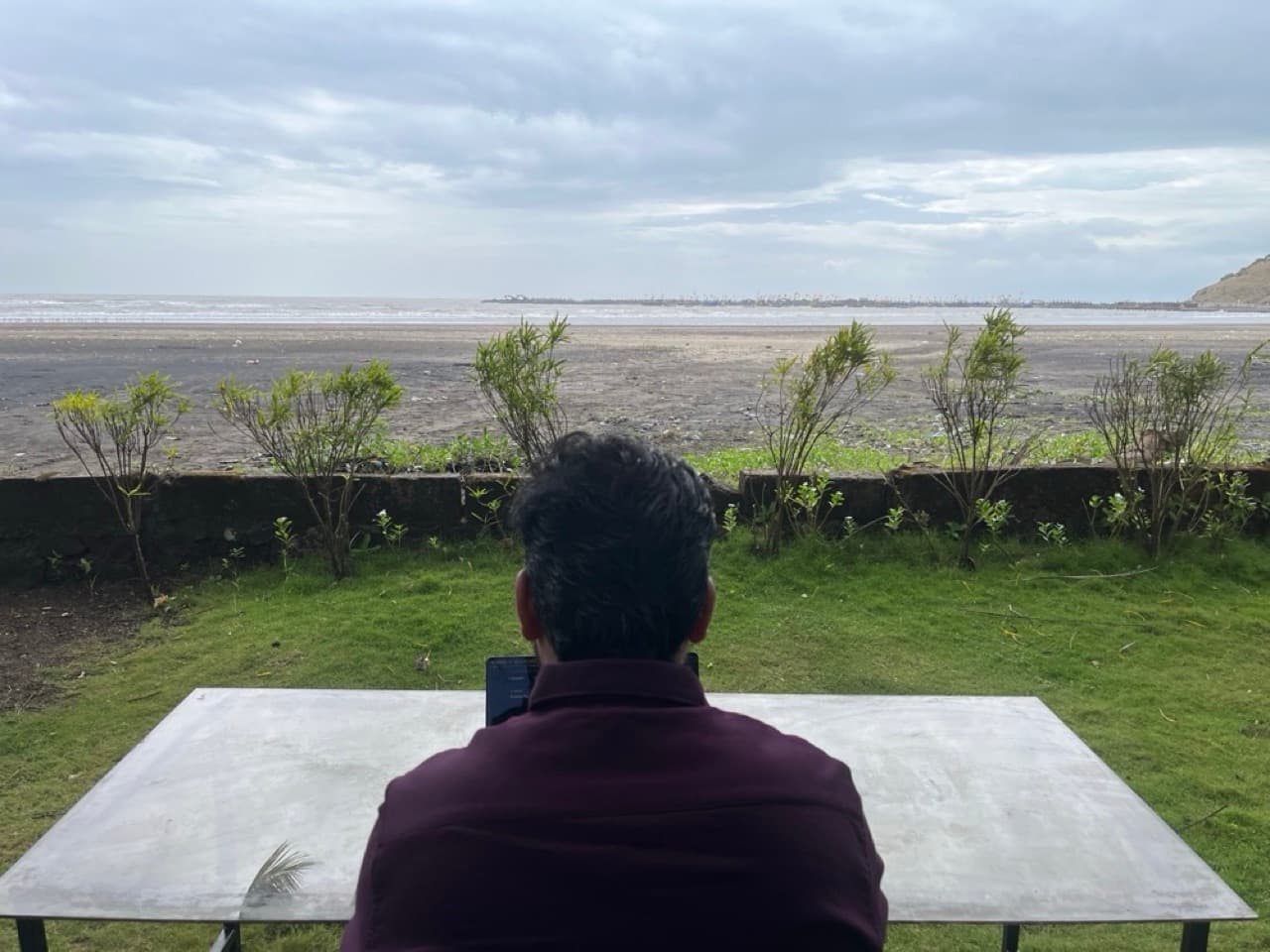 A zerith teammate working at a table overlooking the sea
